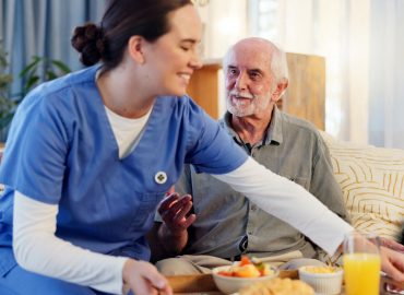 Breakfast, nurse and senior man in nursing home for elderly care, nutrition and support. Retired ma