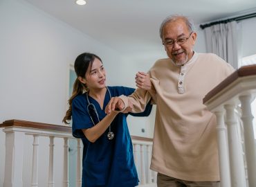 Nurse helping the elderly walk up the stairs