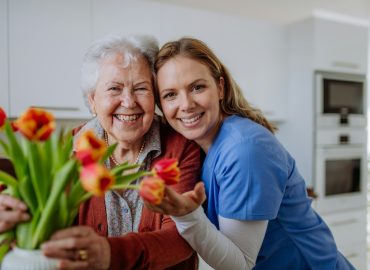 senior-woman-and-nurse-with-tulip-bouquet-.jpg